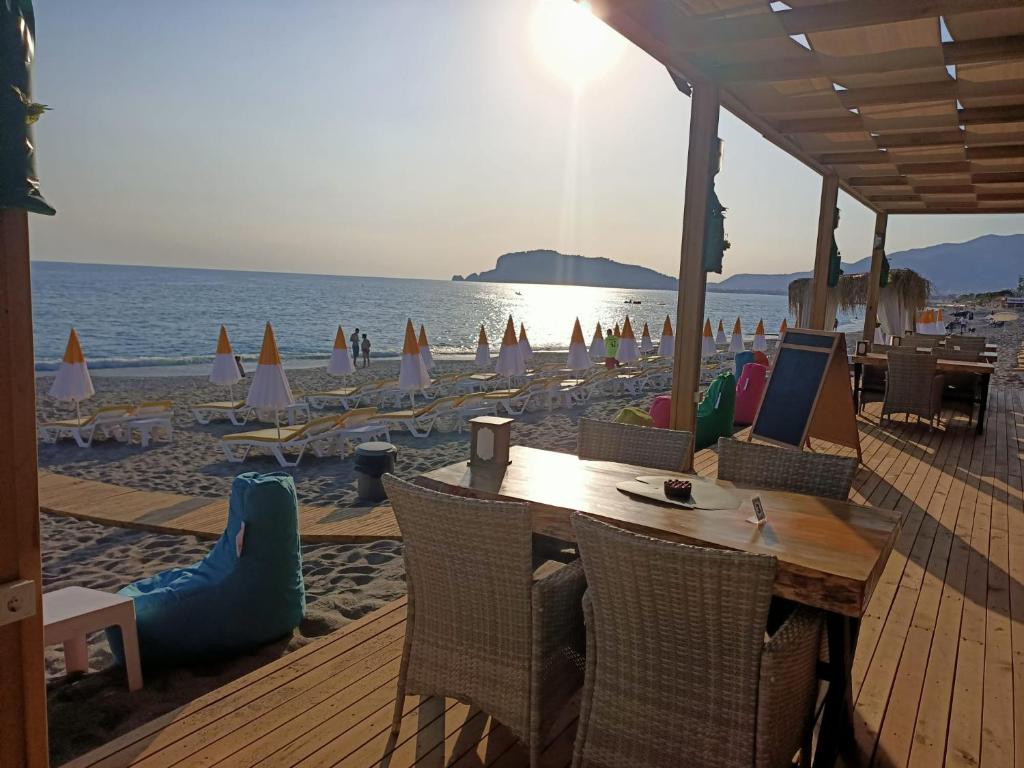 阿拉尼亚Bora Bora Butik Hotel的海滩上设有桌椅,大海上设有沙滩