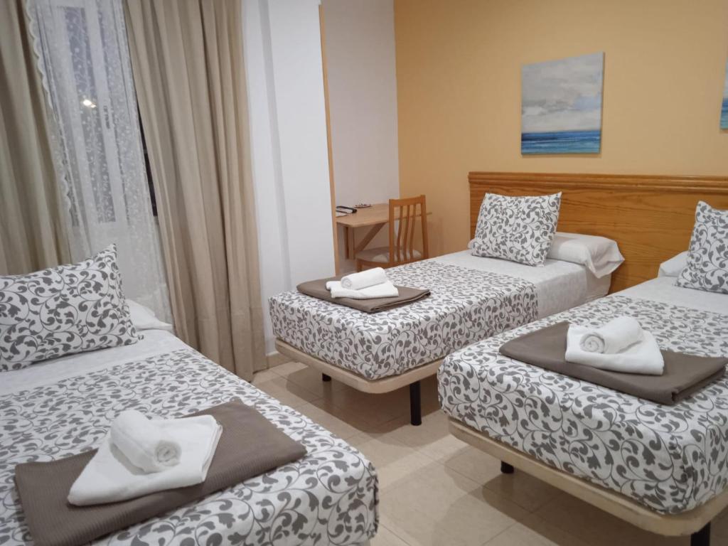 El ÁlamoH El ALAMO MADRID的酒店客房设有两张床和一张桌子。