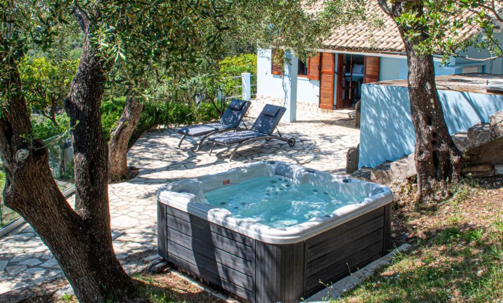 Áno KorakiánaThe Little House Corfu的树旁的院子内的热水浴池