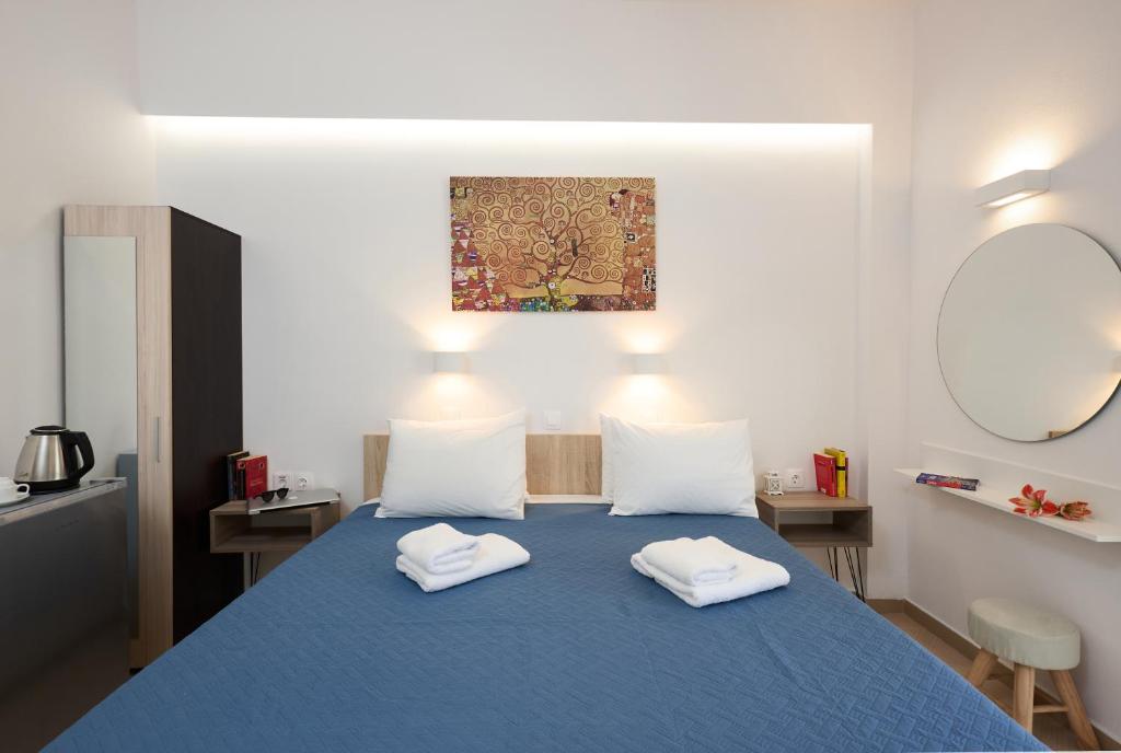 普拉基亚斯Afroditi Hotel的一间卧室配有蓝色的床和2条白色毛巾