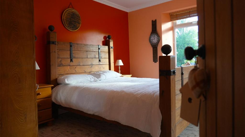 滕比Habititabities的一间卧室配有一张带橙色墙壁和窗户的床