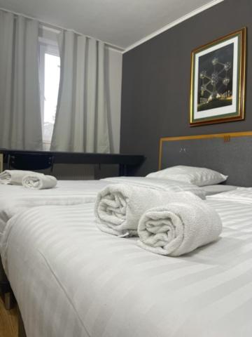 布鲁塞尔Hotel Bentley New的卧室配有2条白色毛巾。