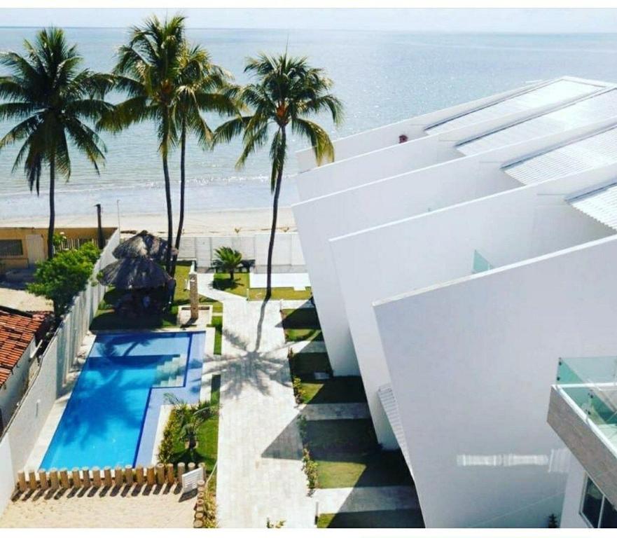 保利斯塔Maria Farinha Residence Prince - LocarHouse的享有度假胜地的空中景致,设有游泳池和海滩