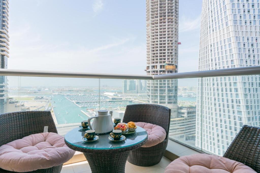 迪拜Vacay Lettings -2 Bed Iris Blue Dubai Marina的配有大窗户的客房内的桌椅