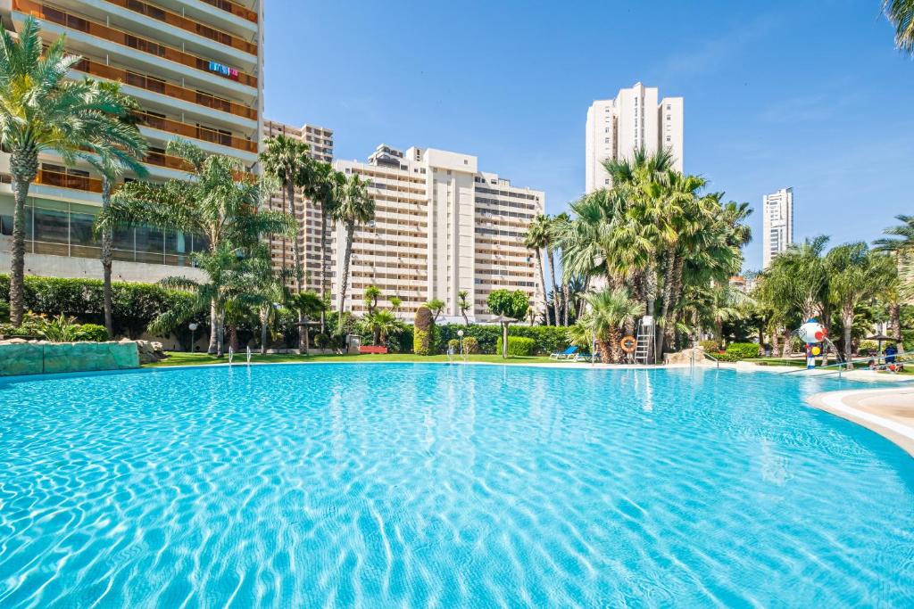 贝尼多姆Gemelos 22 Resort Apartment 3-18-B Levante Beach的一座棕榈树和建筑的大型游泳池