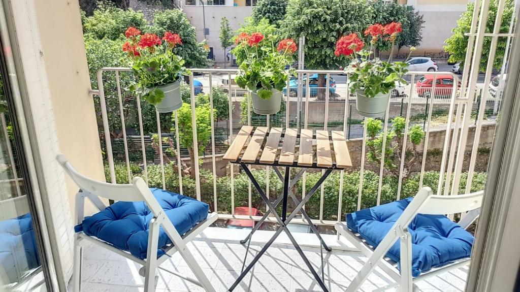 尼斯Superbe appartement style architecte/unique**的阳台上摆放着两把椅子和一张桌子,阳台上摆放着鲜花