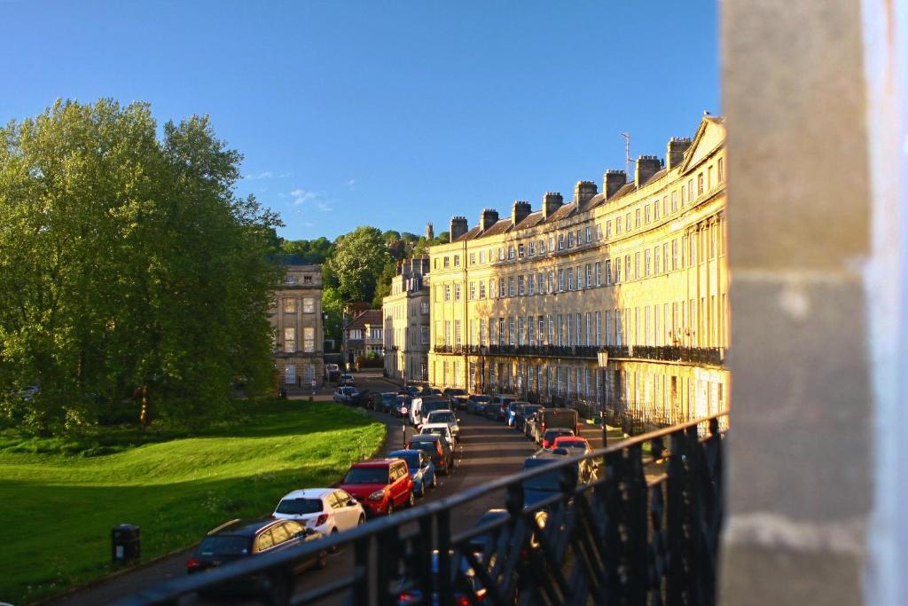 巴斯A Rare Georgian Crescent Residence with parking的停在建筑物旁边的街道上的一排汽车