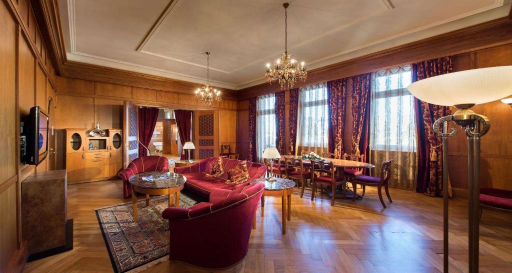 弗罗伊登施塔特Das Palmenwald Schwarzwaldhof, BW Signature Collection的一间带红色家具的客厅和一间餐厅