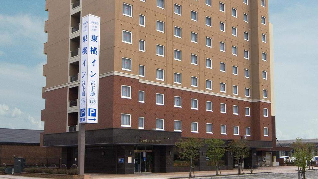 旭川Toyoko Inn Hokkaido Asahikawa eki Higashi guchi的前面有标志的高楼