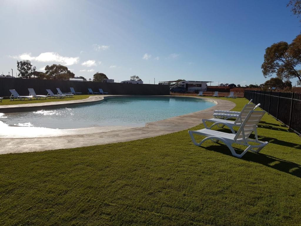 库伯佩迪BIG4斯图尔特宁治澳拜客假日公园的一个带两把白色椅子的游泳池