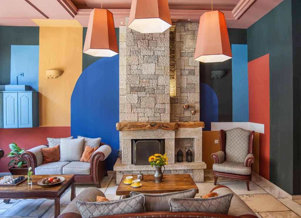 特尔斐巴纳索斯德尔菲酒店的客厅设有色彩缤纷的墙壁和壁炉