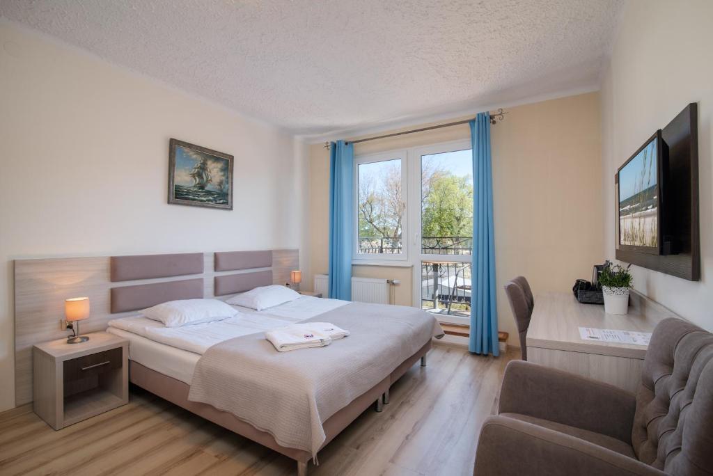 弗瓦迪斯瓦沃沃韦斯特民宿的一间卧室配有一张床、一张沙发和一个窗口