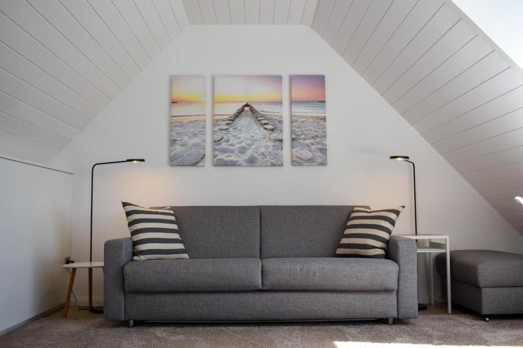诺德奈Wohnung Wattwurm的客厅配有沙发和墙上的两幅画作