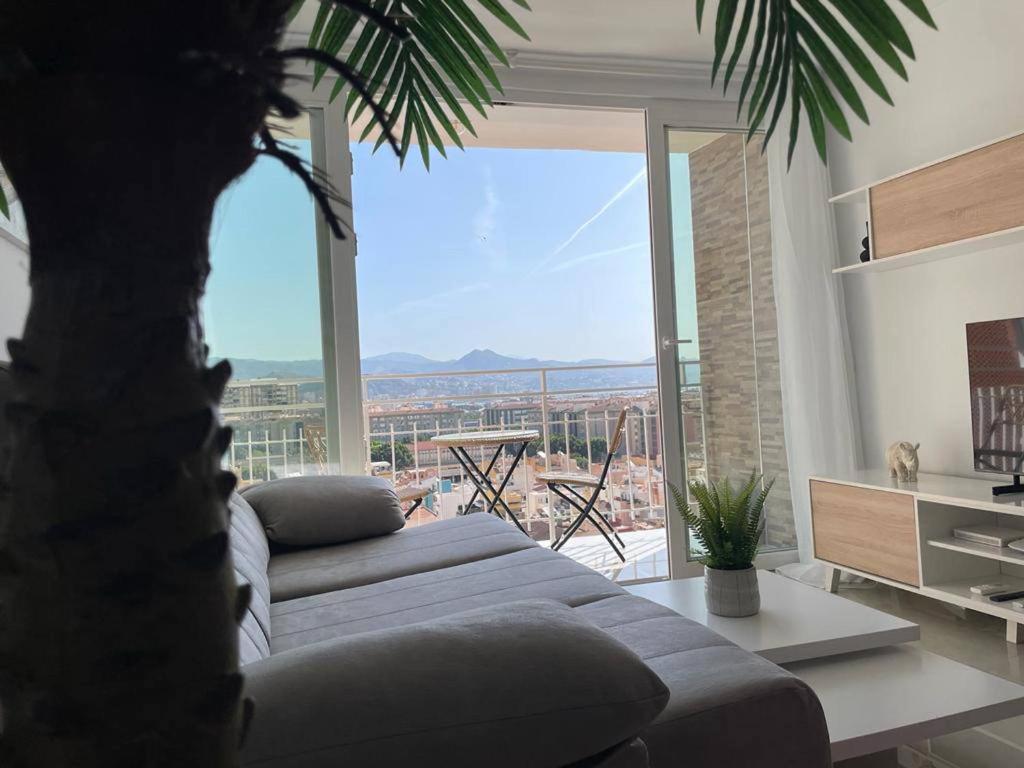 马拉加Holidays2Malaga Princesa 3 dormitorios, vistas al mar y montaña, terraza y a 200m a la playa的带沙发和大窗户的客厅