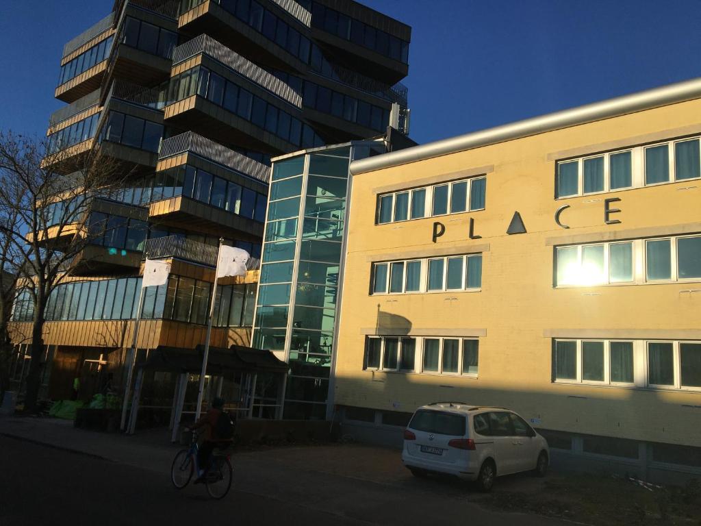 隆德Place Lund的一个人在建筑物前骑着自行车