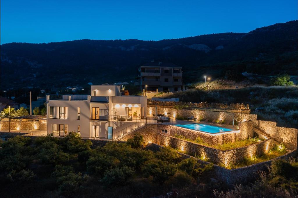 科米扎Luxury Villa Envivo Komiža with heated pool and professional gym的享有别墅空中景色,晚上设有游泳池