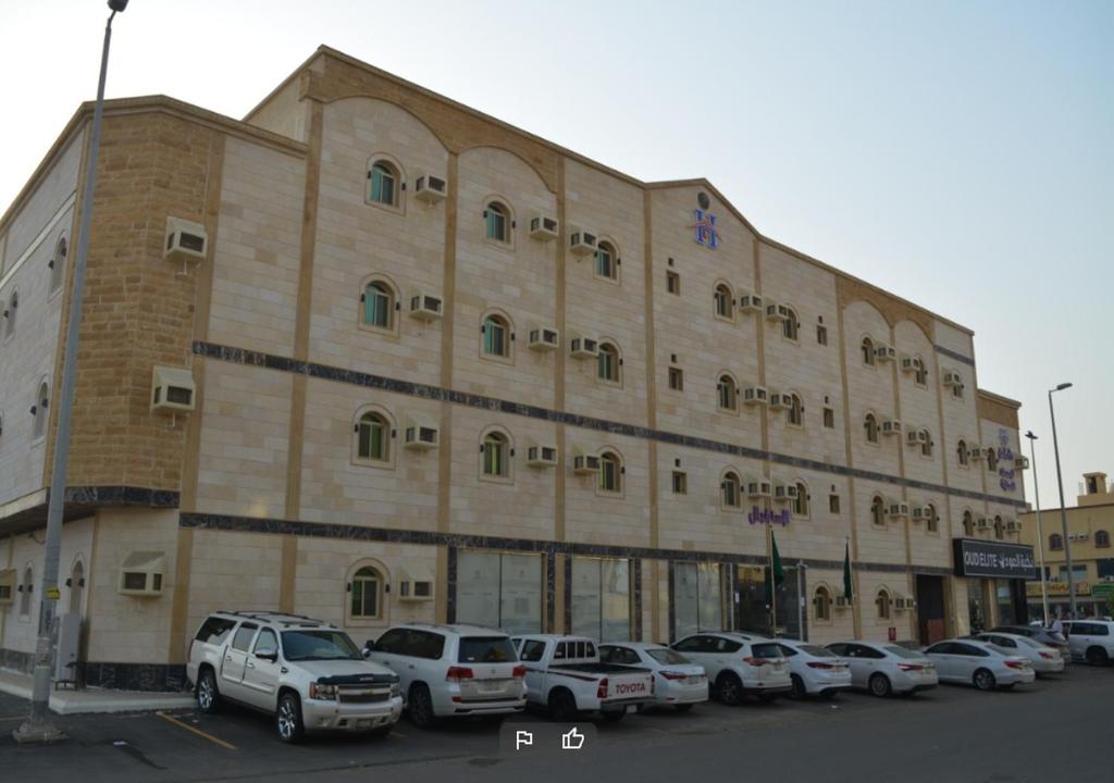 Al Kuraهمم للوحدات السكنية - الرحيلي Jeddah的停车场内停放汽车的大型建筑