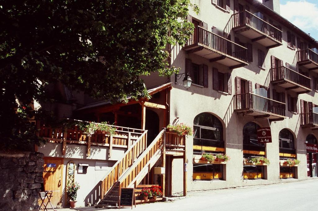 拉格拉沃HOTEL DES ALPES - SKIERS LODGE的街道上带阳台和楼梯的建筑