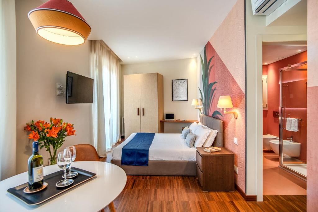 米兰Milhouse Suites Duomo的酒店客房配有一张床铺和一张桌子。