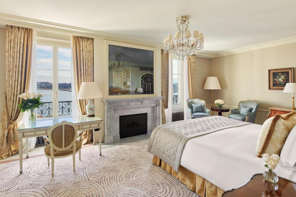 日内瓦Beau-Rivage Genève的一间卧室配有一张床、一张桌子和一个壁炉