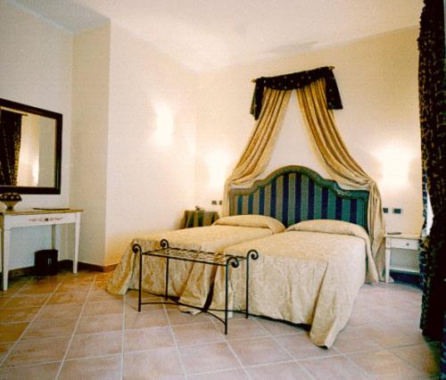 蒙蒂菲阿斯科尼尔巴诺伍酒店的一间卧室配有一张带天蓬的床