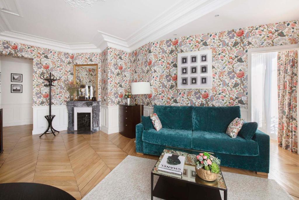 巴黎LE BEAU MARAIS - Luxury Apartments, AIR COND, LIFT的客厅配有蓝色的沙发和花卉壁纸