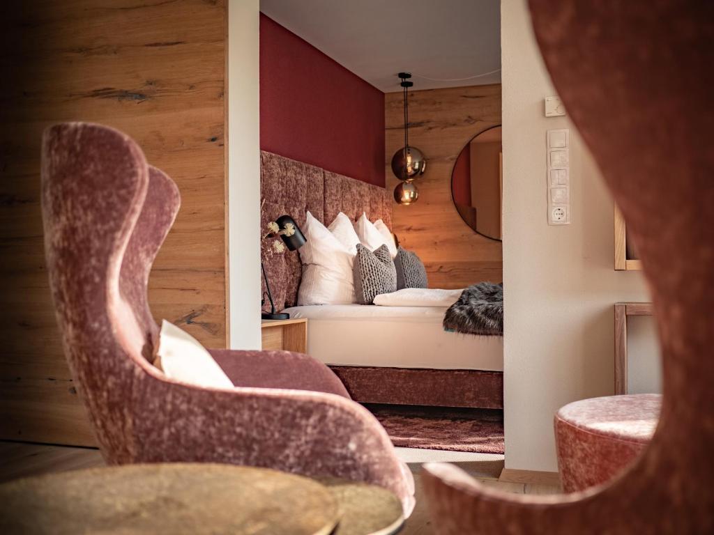 菲尔斯Alpenchalet Vils Tirol的酒店客房,配有一张床和两把椅子