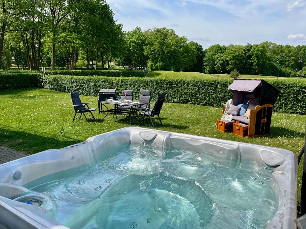 格赫伦-莱宾Blick ins Grüne- Premium-FeWo的庭院内的热水浴池,配有桌椅