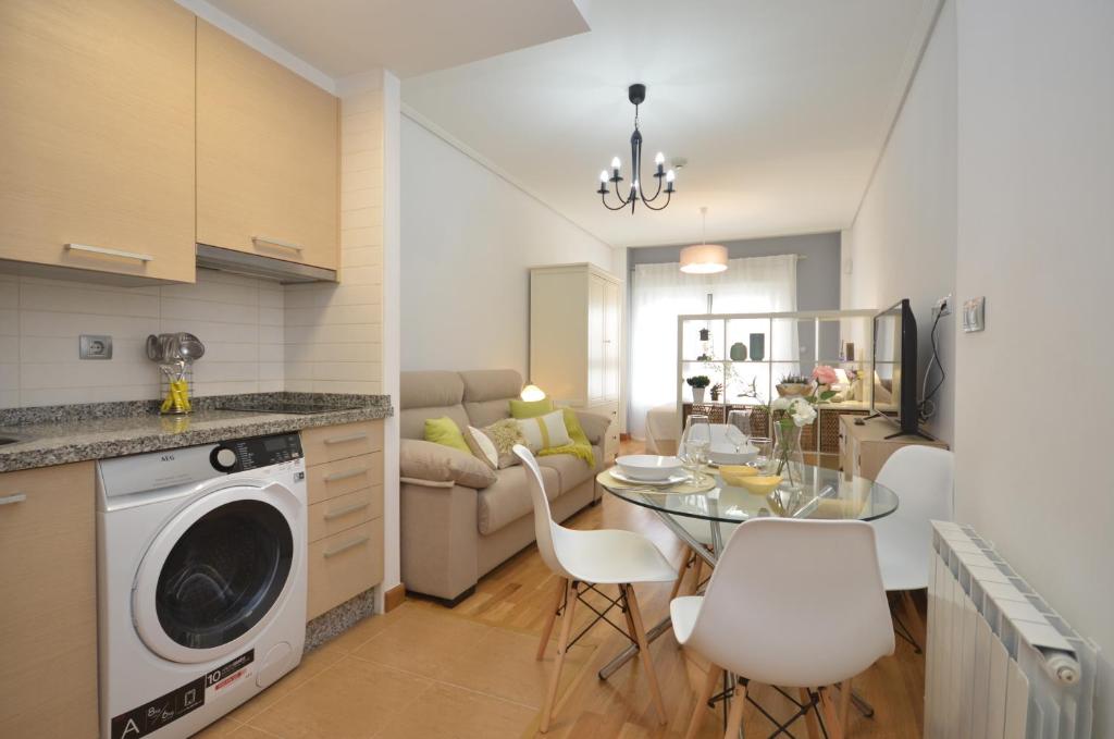 维戈Apartamento zona exclusiva garaje gratis y Netflix的厨房以及带桌椅的起居室。