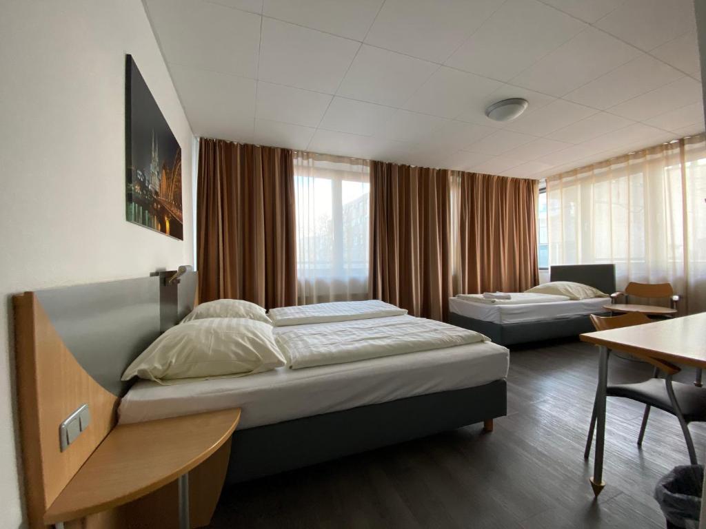 科隆科隆歌剧院酒店的一间卧室配有两张床、一张桌子和一张桌子