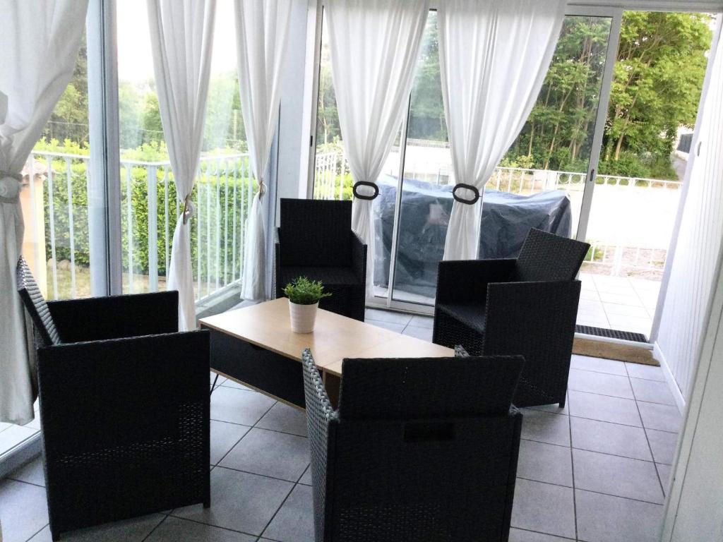 欧布纳les lauriers roses的一间带桌椅和窗户的用餐室