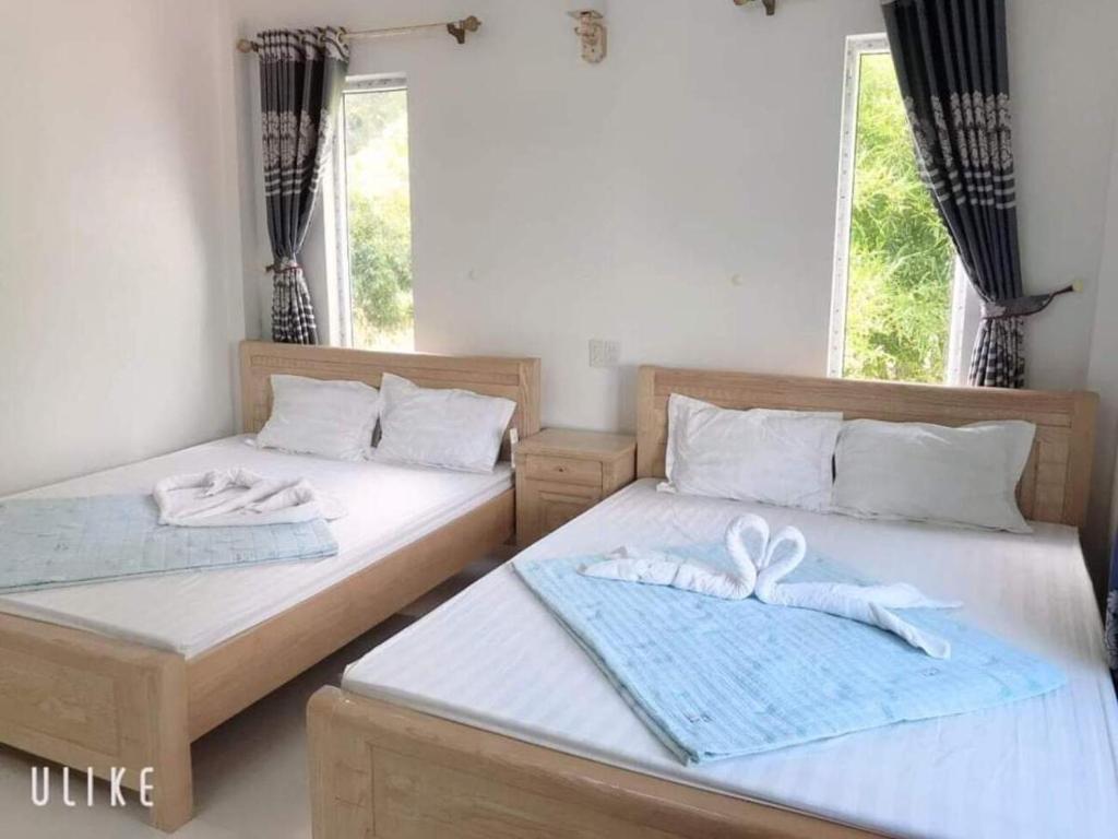 广宁Song Châu Villa Quan Lạn的配有两张床的房间的两张床