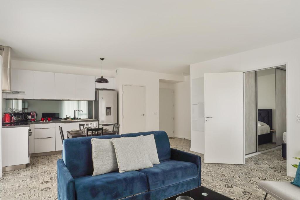 拉罗谢尔Appartement des Tours - Welkeys的一间带蓝色沙发的客厅和一间厨房