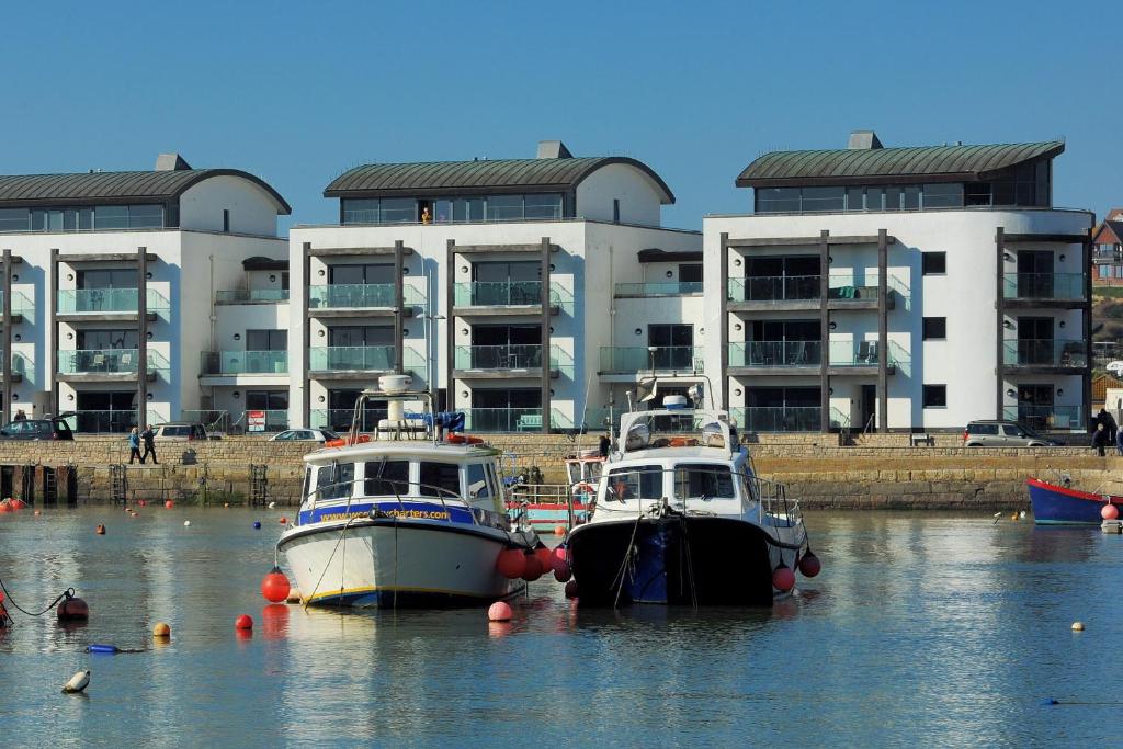 韦斯特贝Harbour View的两艘船在水中,在建筑物前