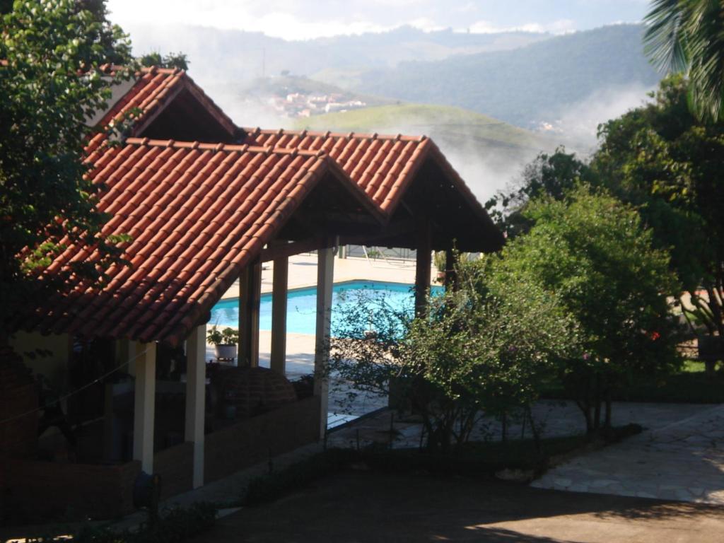 兰巴里Pousada Lambari Montanha Hotel的湖畔房屋,带凉亭