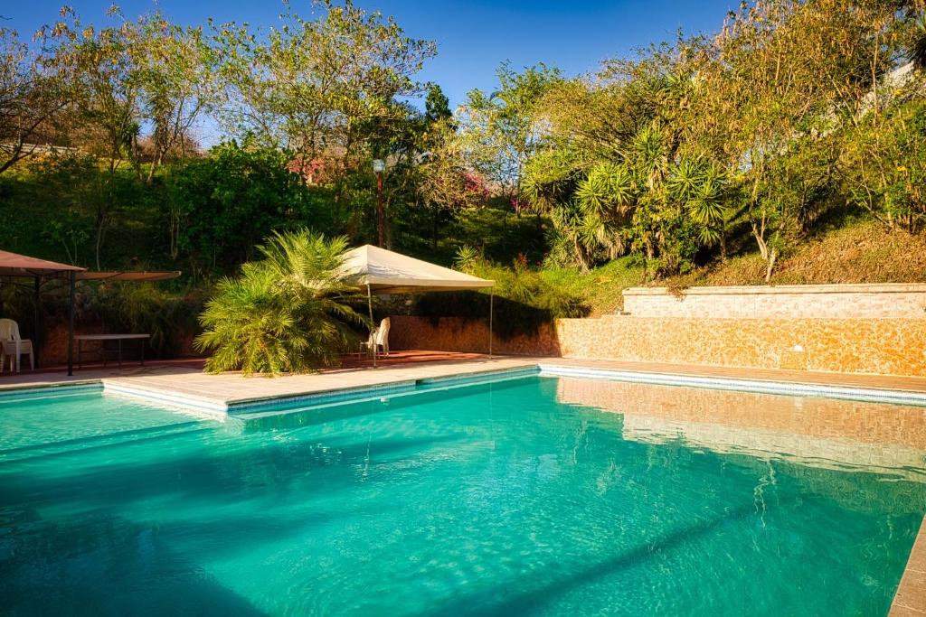 SanarateCasa Santa Teresita - Cabaña familiar tipo glamping的庭院里的一个蓝色海水游泳池