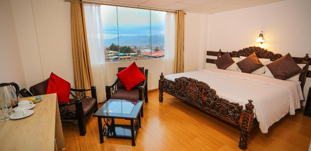 库斯科Hotel Kapac Inn-San Blas的一间卧室配有一张床、一张桌子和一个窗户。