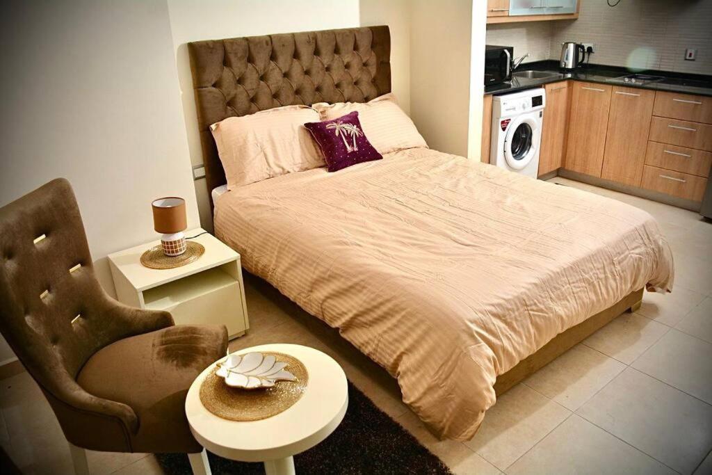 迪拜Cosy Studio in Marina的一间卧室配有一张床、一把椅子和一张桌子