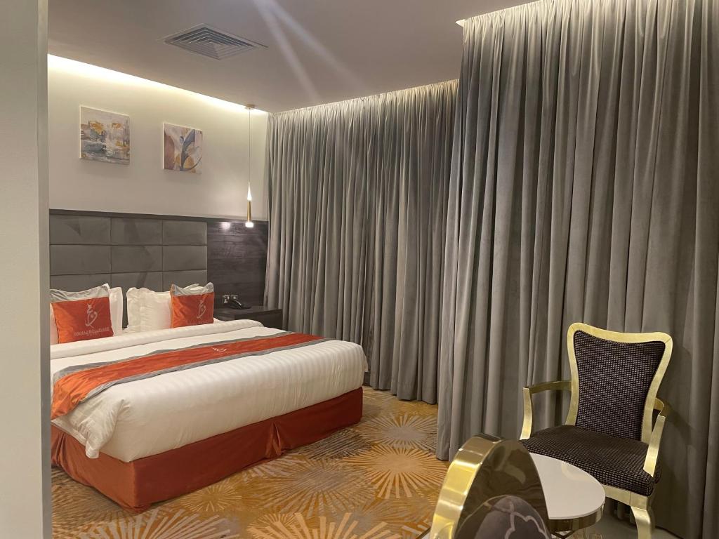 科威特瓦哈2号酒店式公寓的配有一张床和一把椅子的酒店客房