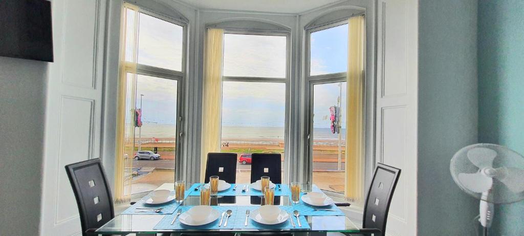 布莱克浦Charlton Aparthotel的一间带桌椅和窗户的用餐室