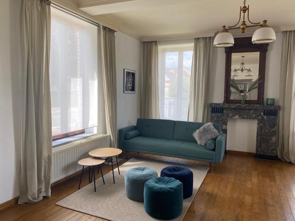 KortessemHuis Louis的客厅配有蓝色的沙发和凳子