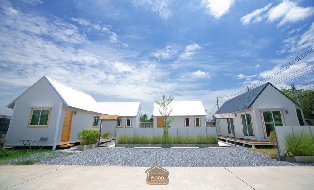 佛统Barn Sampran Resort บ้านสามพรานรีสอร์ท的院子内一排白色的房子