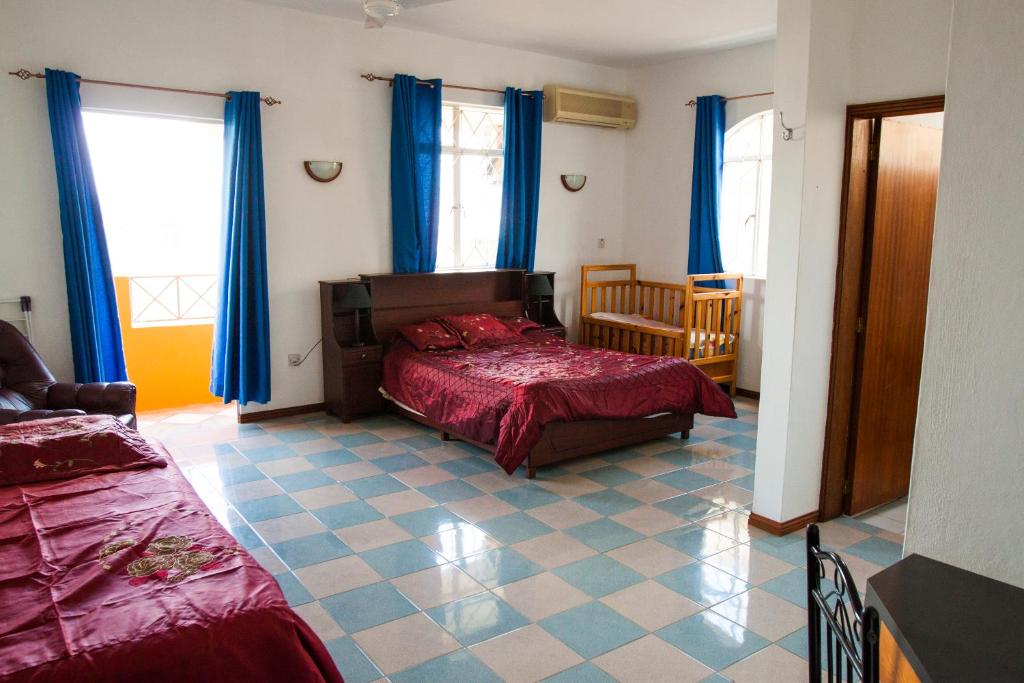 特鲁欧克比赫斯The Impala Mauritius Bed & Breakfast的一间卧室配有床和蓝色窗帘