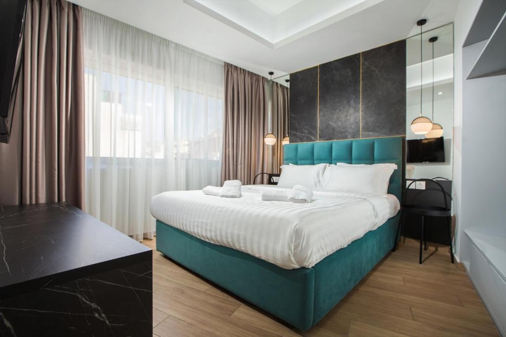 雅典Xclusive Athens Suites的一间卧室配有一张大床和蓝色床头板