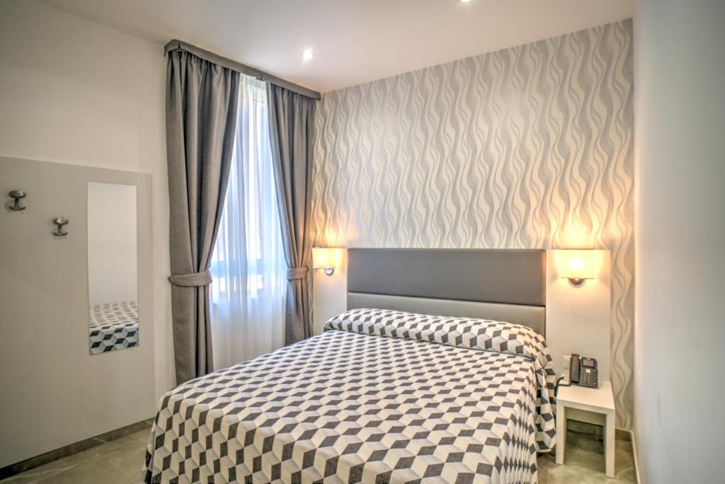 奇维塔韦基亚波尔图迪罗马酒店的一间卧室配有一张带 ⁇ 子毯子的床