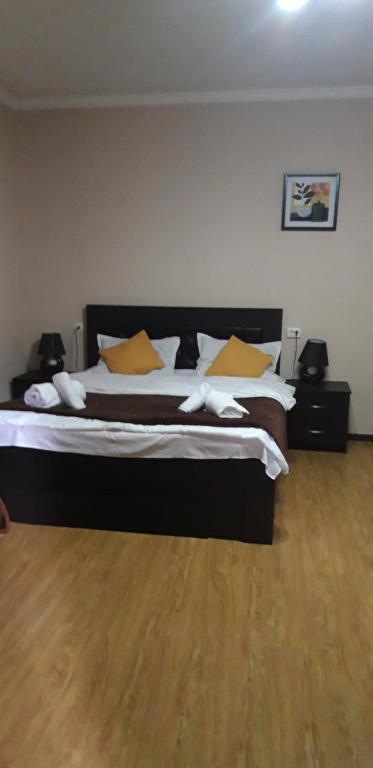博尔若米Ira & Vaso's guest house Borjomipark的一间卧室配有一张带黄色枕头的大床