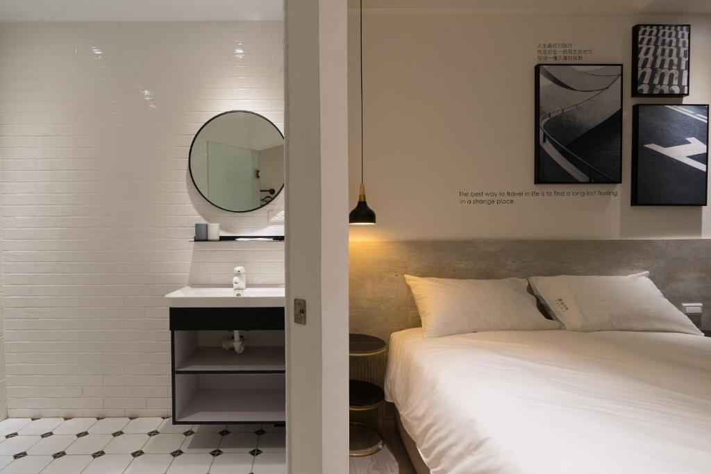 台中市乐微行旅的一间卧室配有床、镜子和水槽