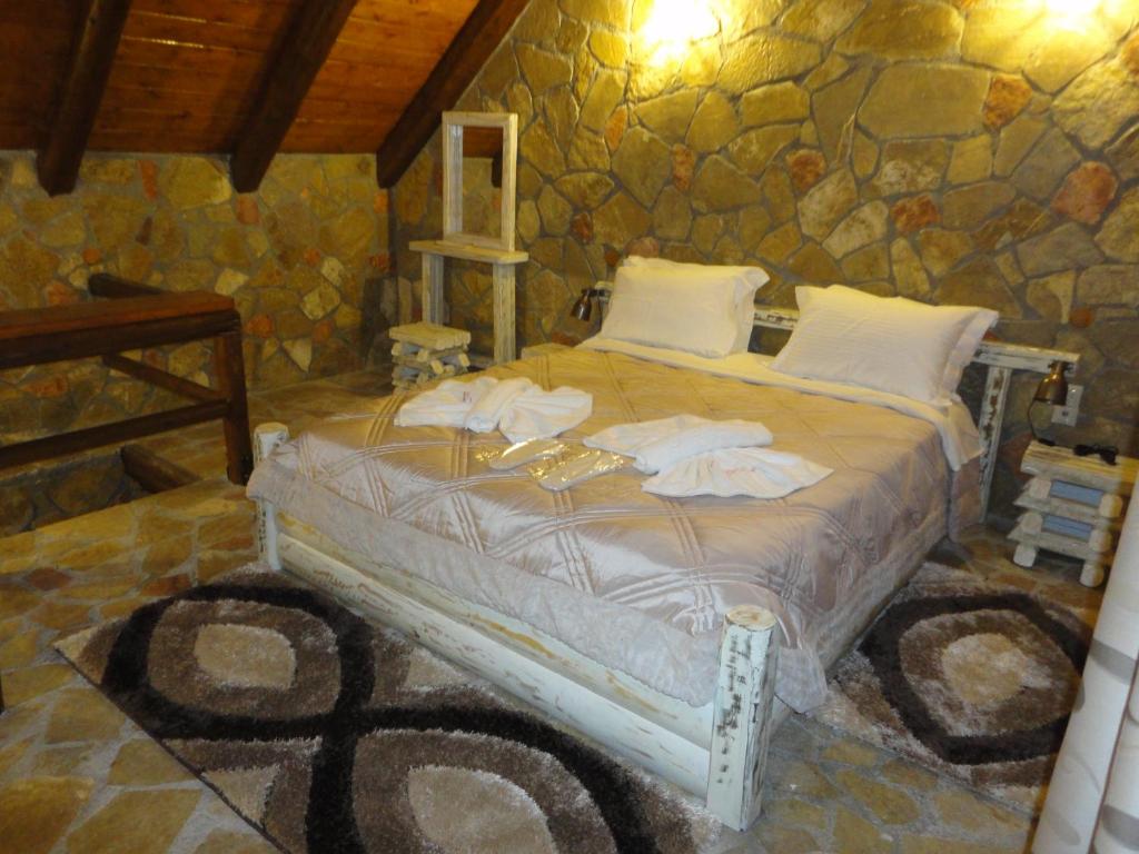 卡拉维塔eco oneiro resort的卧室配有一张石墙床