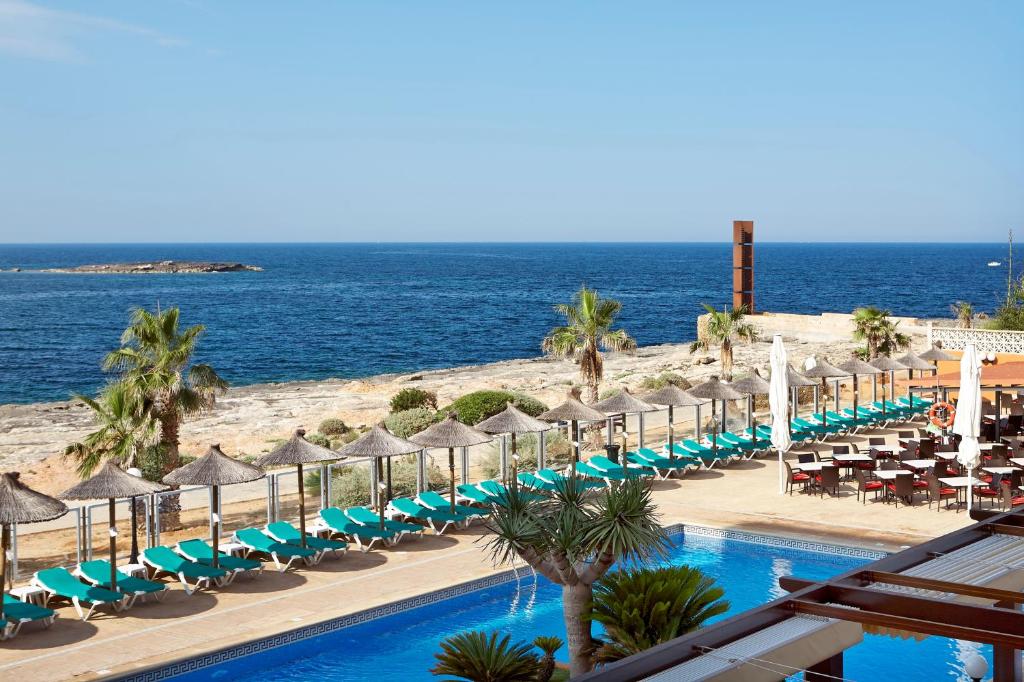 科洛尼亚圣霍尔迪浪漫环球酒店的毗邻大海的带椅子和遮阳伞的游泳池