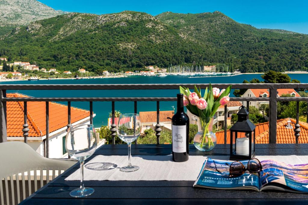 斯拉诺Amazing Sea View Apartments Petra & Paula的阳台上的桌子上摆放着酒杯和鲜花